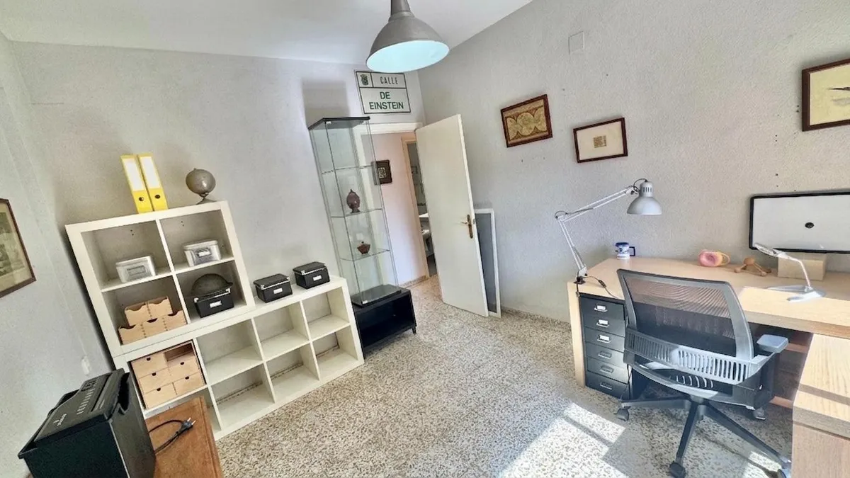 Versatile home office with desk, shelving and generous floor space