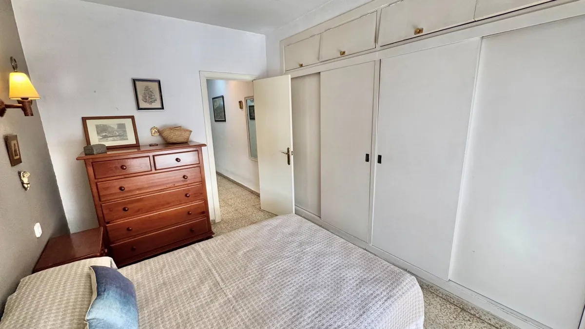 Bedroom with double bed, chest of drawers and full-height fitted wardrobes