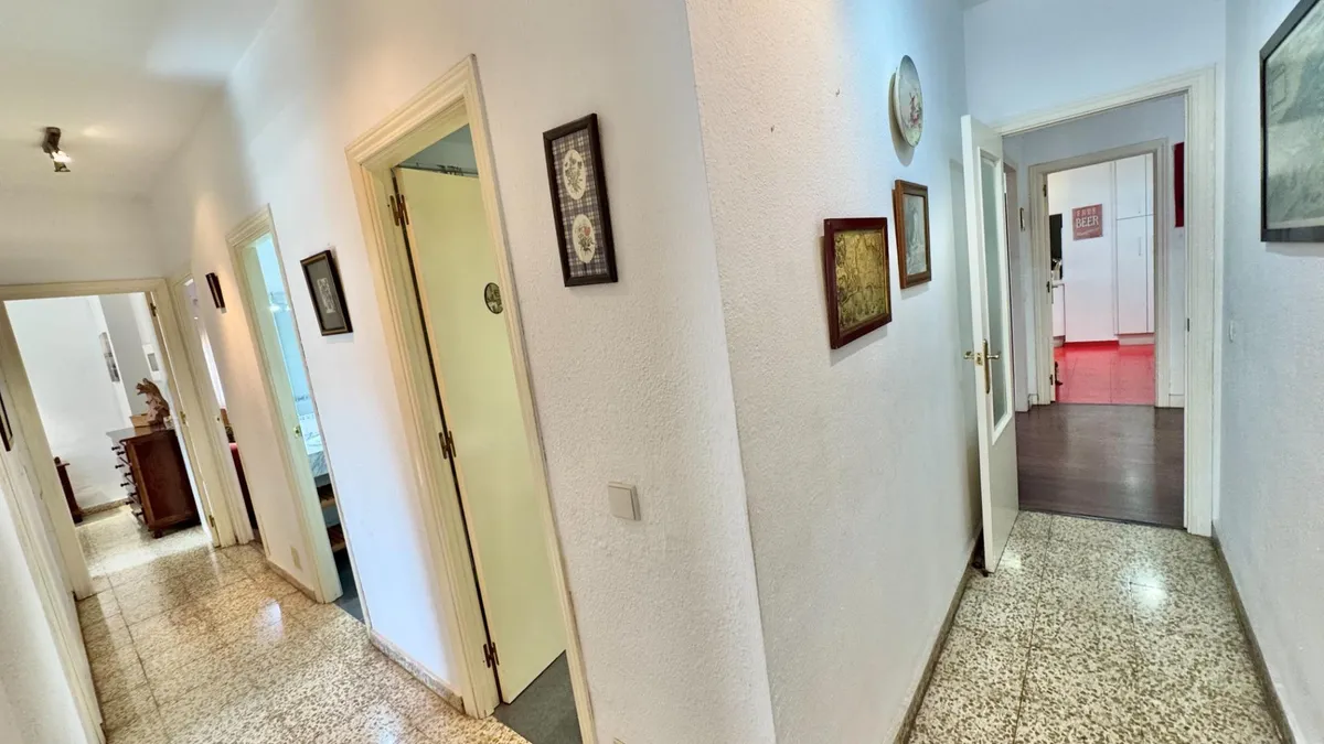 Central apartment hallway connecting the bedrooms and living areas
