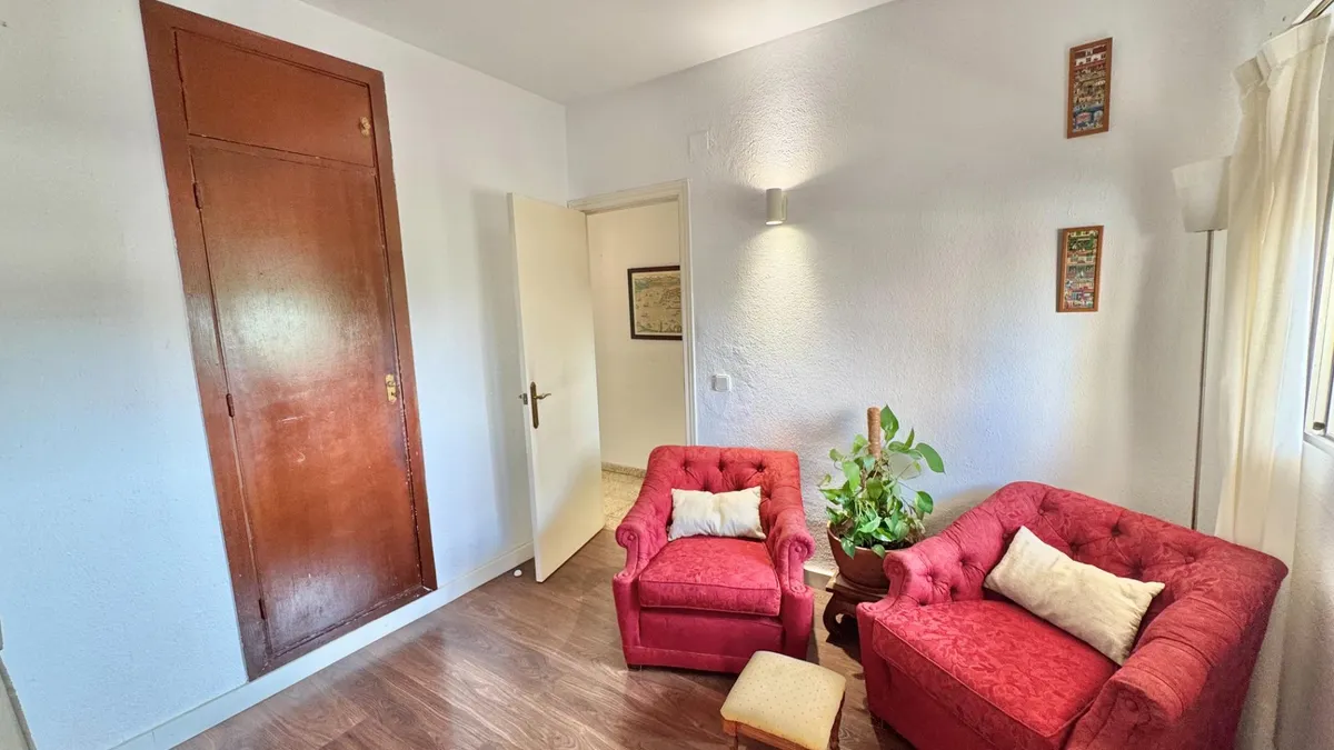 Comfortable red sofa and armchair beside the living-room window