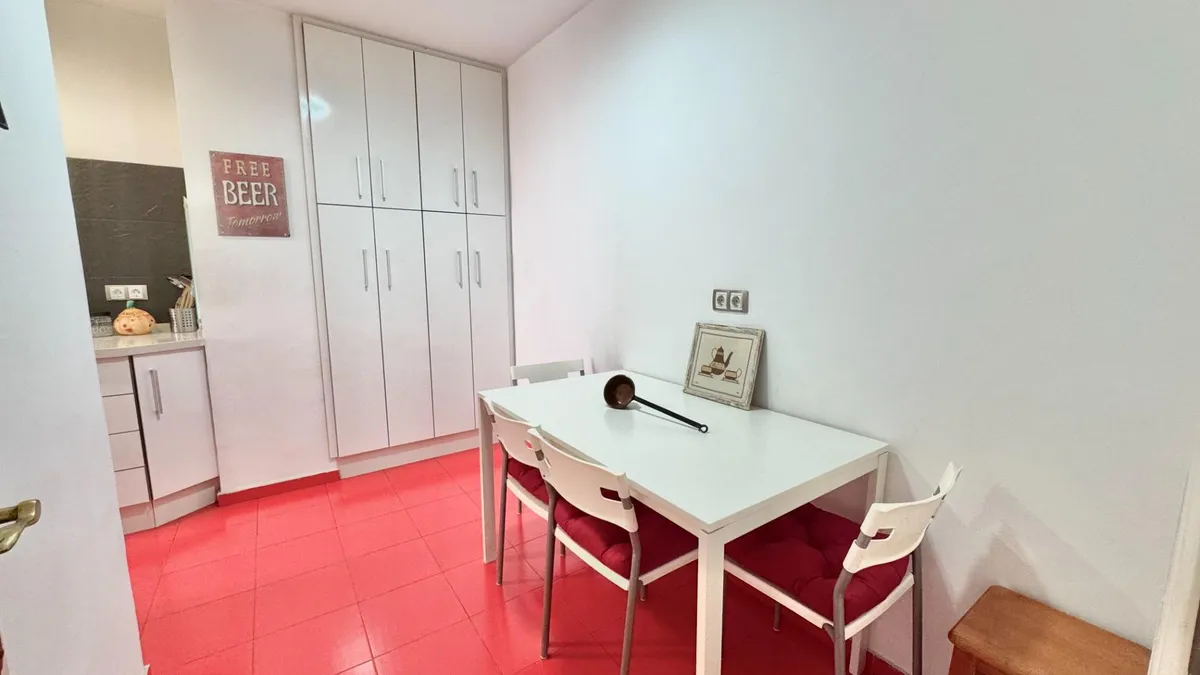 Kitchen breakfast area with white storage and vivid red flooring