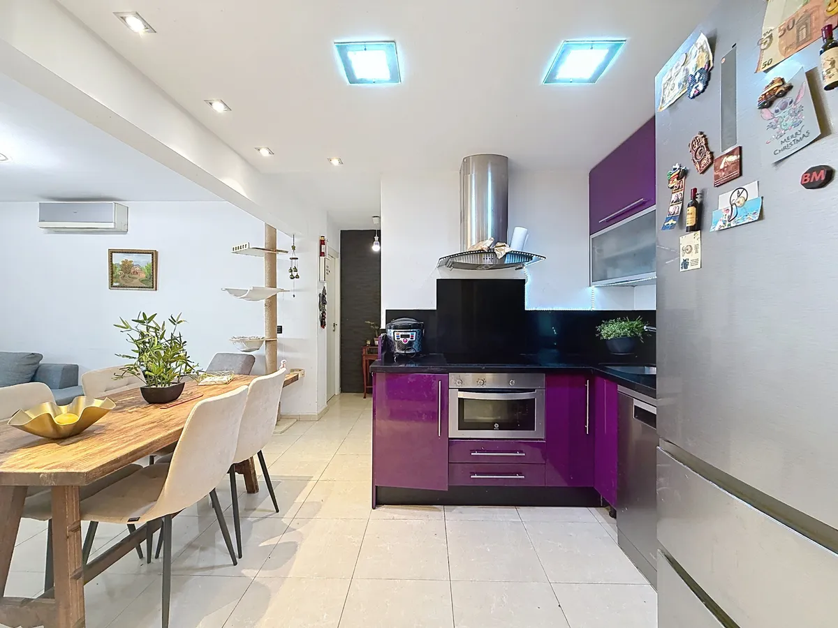 Glossy purple kitchen cabinets with black splashback and worktop