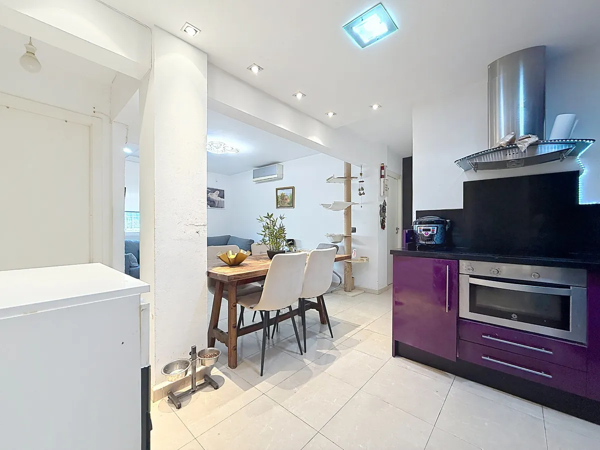 Integrated kitchen viewed across the breakfast counter and dining area