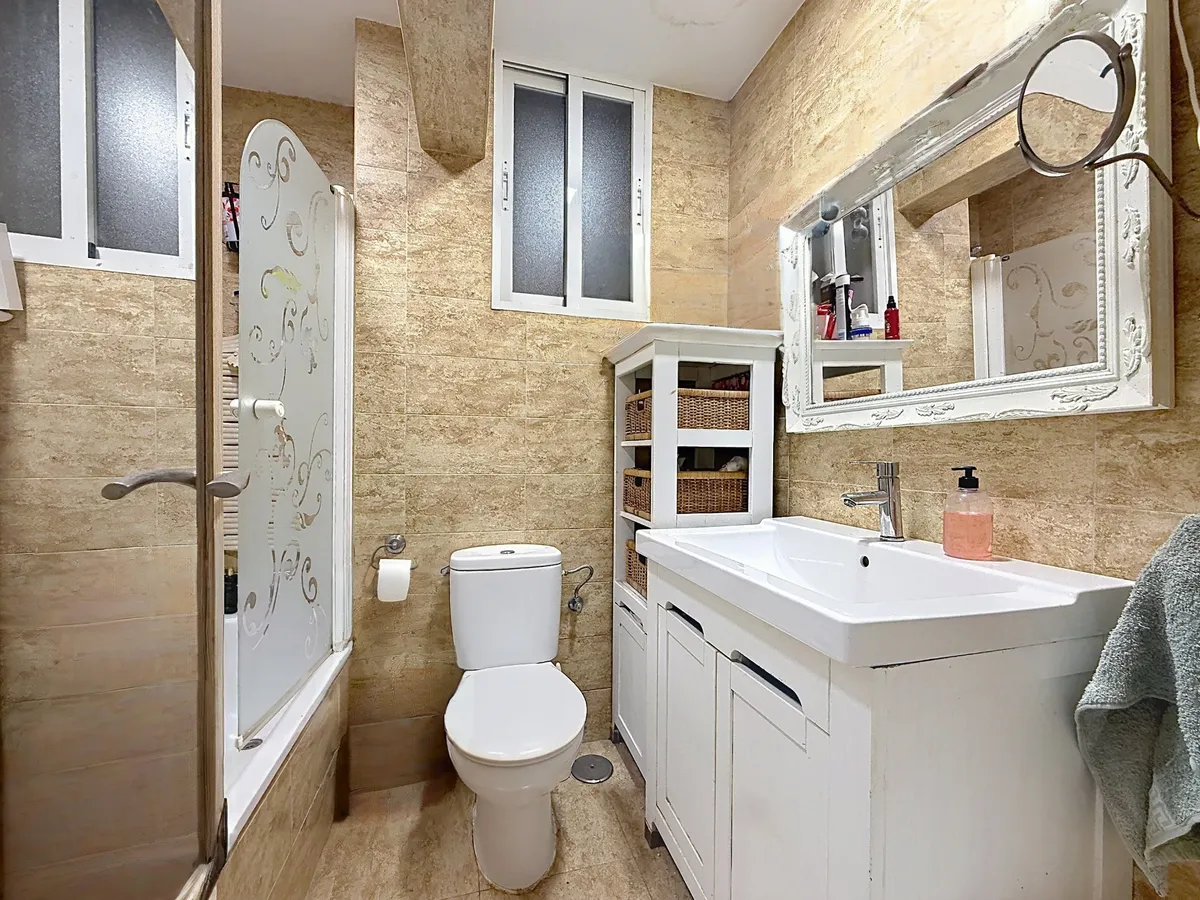 Bathroom shower enclosure beside the toilet and storage vanity