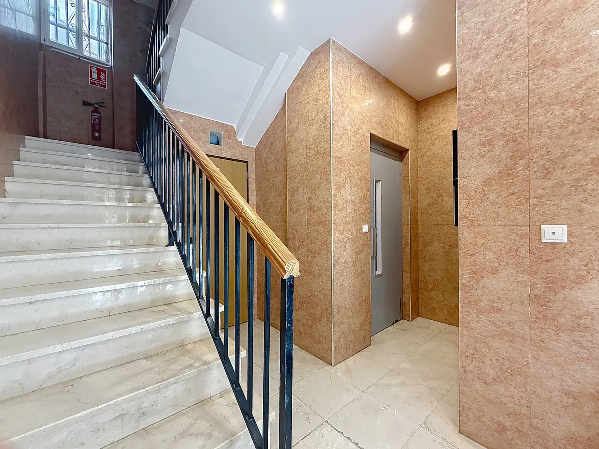 Apartment building stairwell and passenger lift with marble finishes