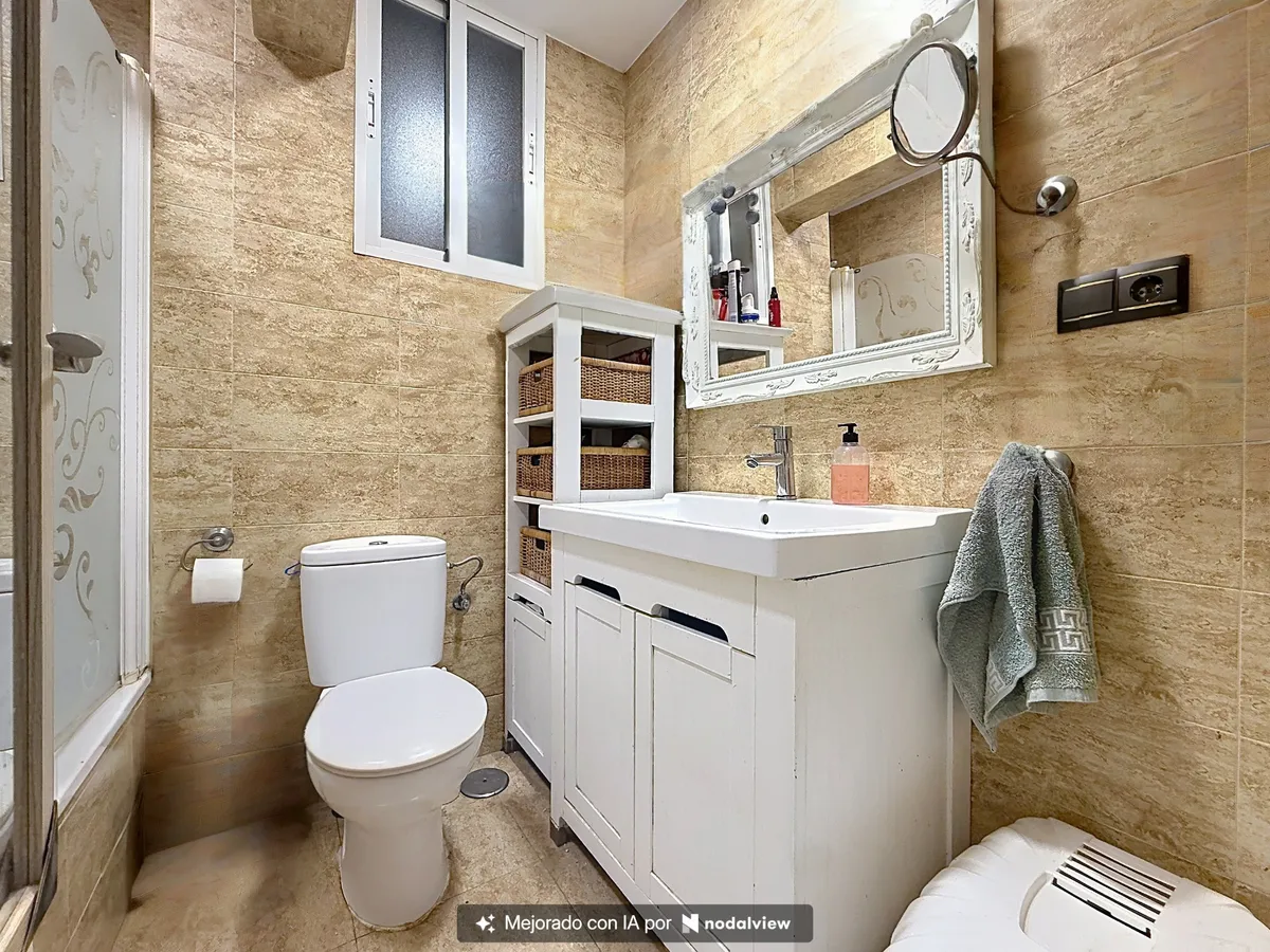 Stone-effect bathroom with curved glass shower and white vanity