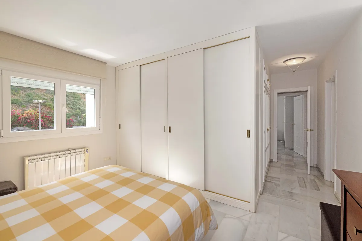 Double bedroom with full-height wardrobe and traditional dresser