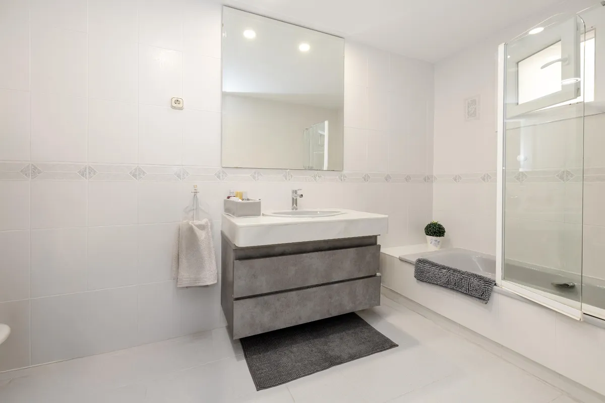 En-suite bathroom with glass shower and broad white vanity