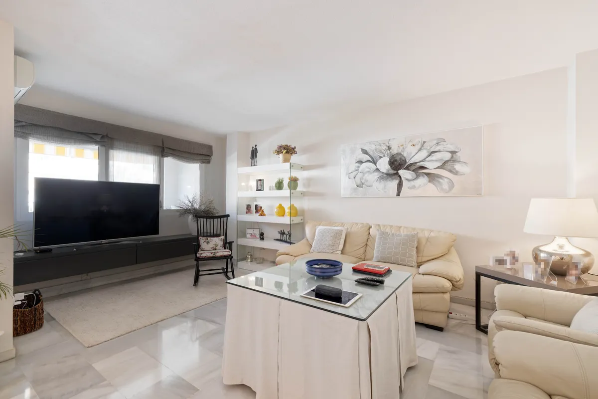 Television lounge with cream sofas and built-in display shelving