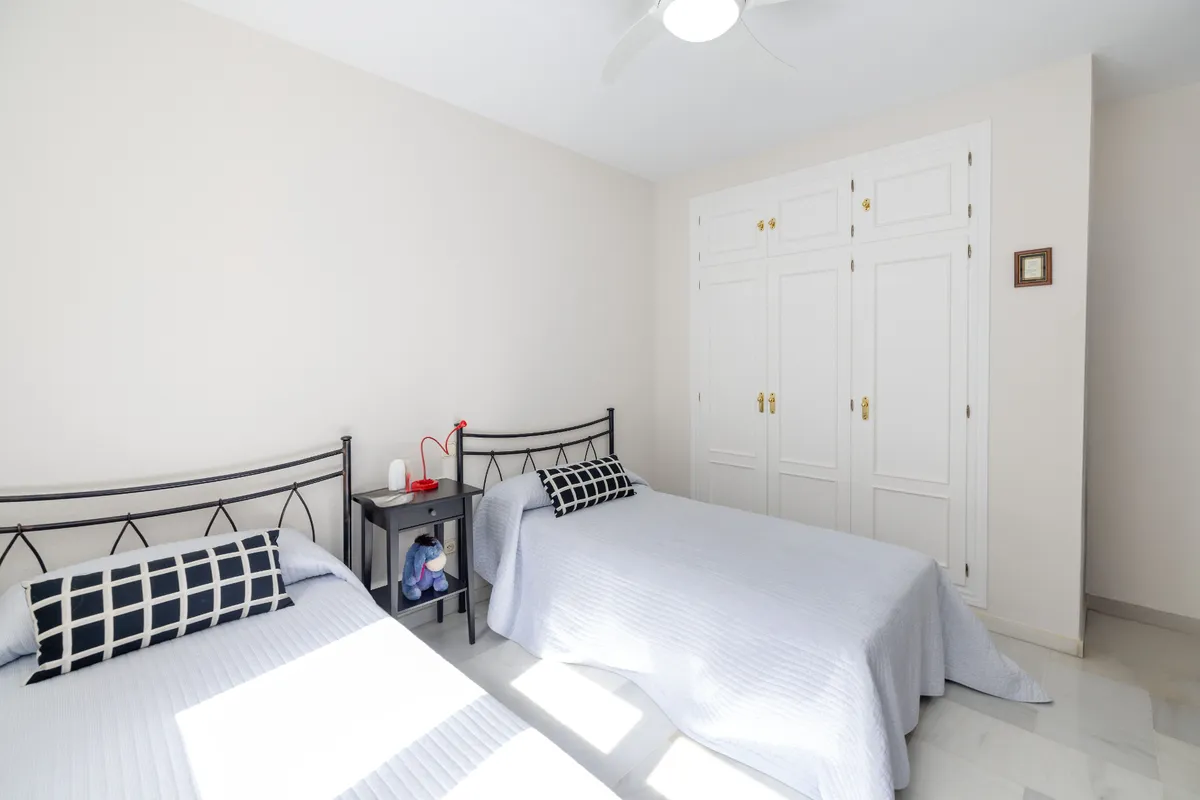 Spacious twin room with dresser, television and fitted wardrobe
