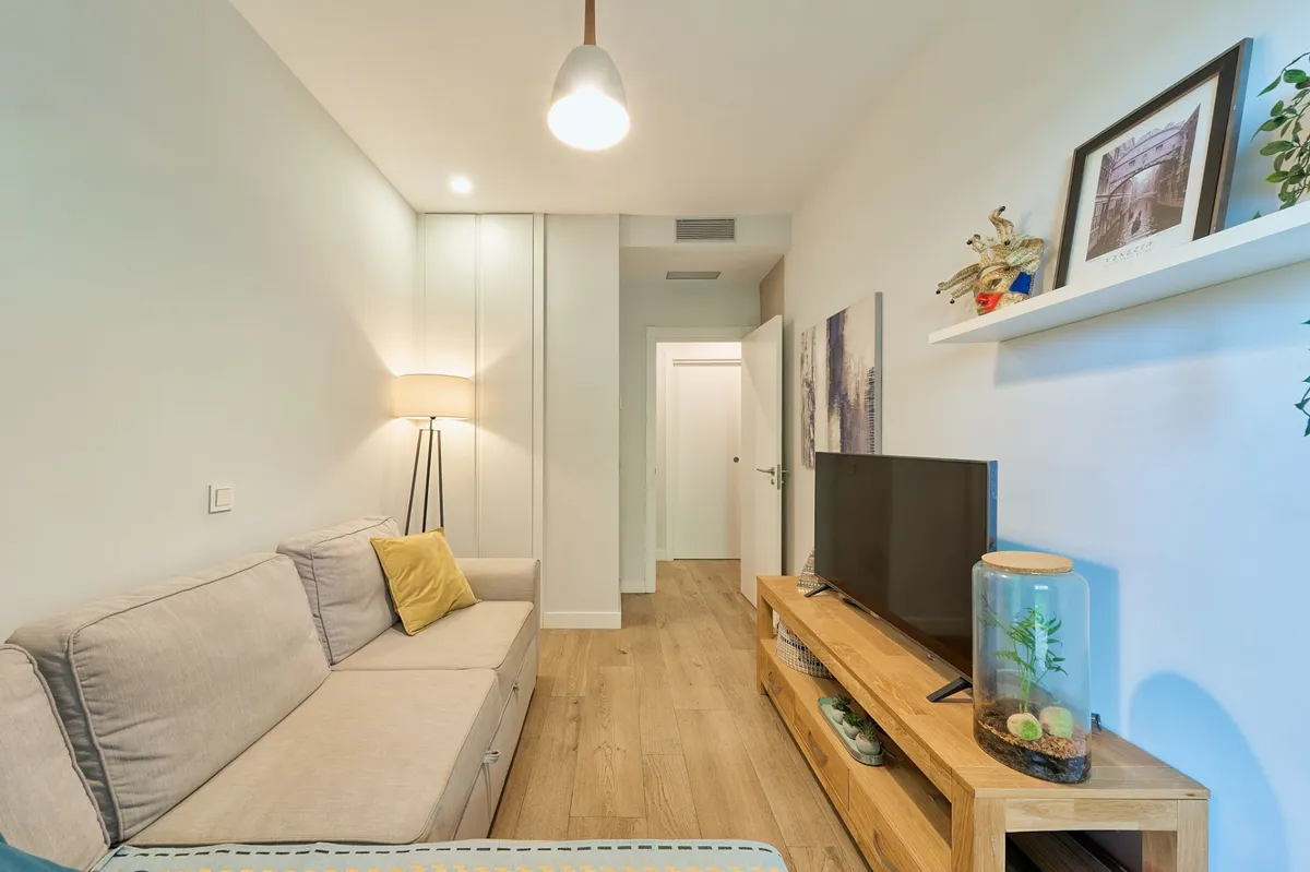 Guest sitting and sleeping room with fitted storage and soft lighting