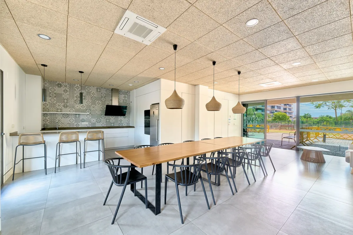 Bright gourmet and social room with kitchen, bar and long dining tables