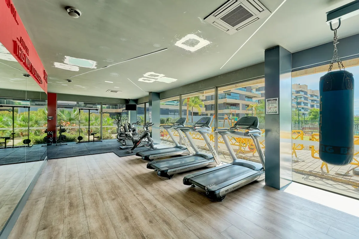 Private residents’ gym with cardio machines, weights and boxing bag