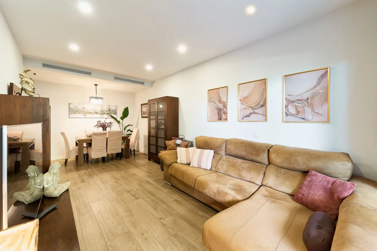Spacious living room with tan sofa and contemporary wall art