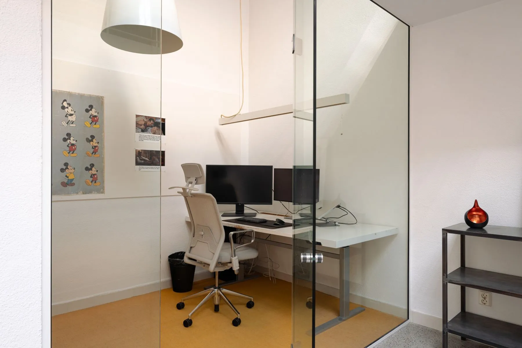 Dedicated glass-fronted office with dual monitors and ergonomic chair