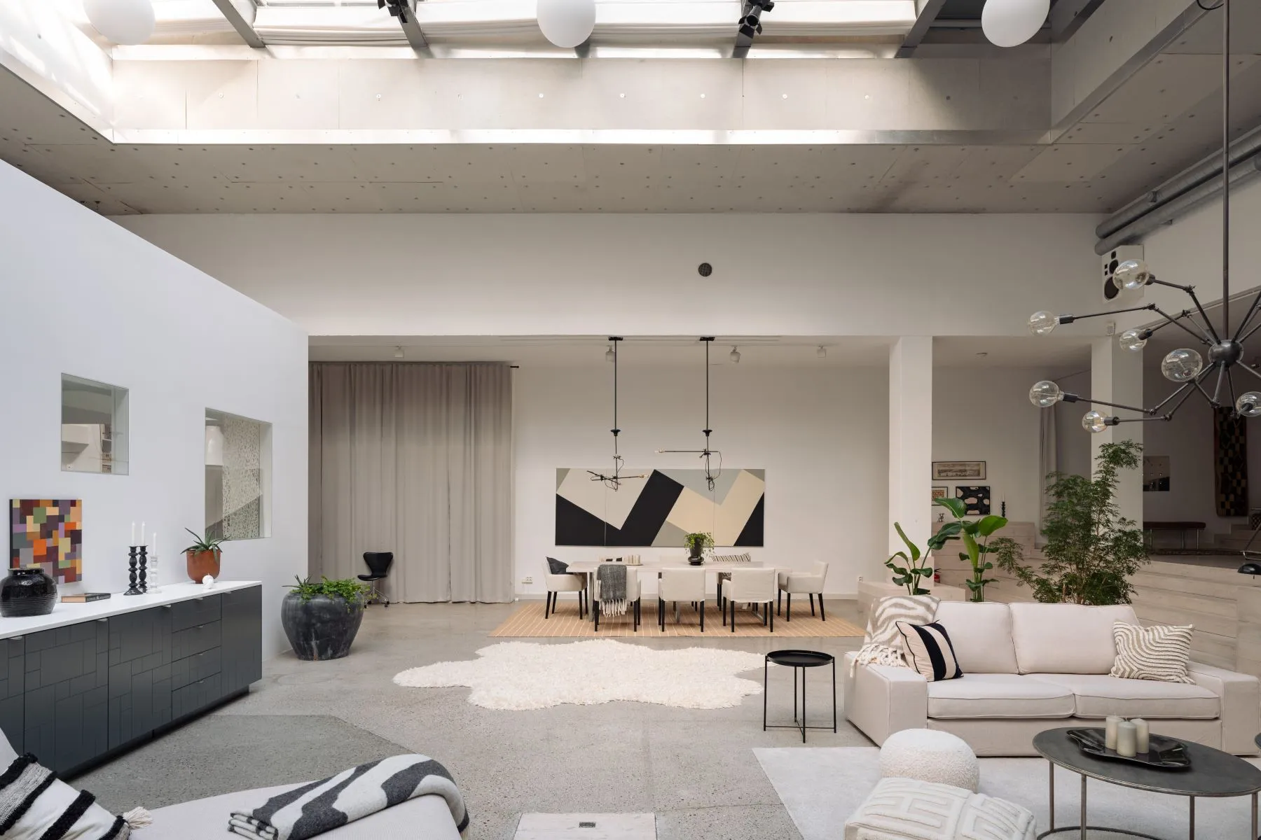 Formal dining table and elegant lounge beneath the soaring cinema ceiling