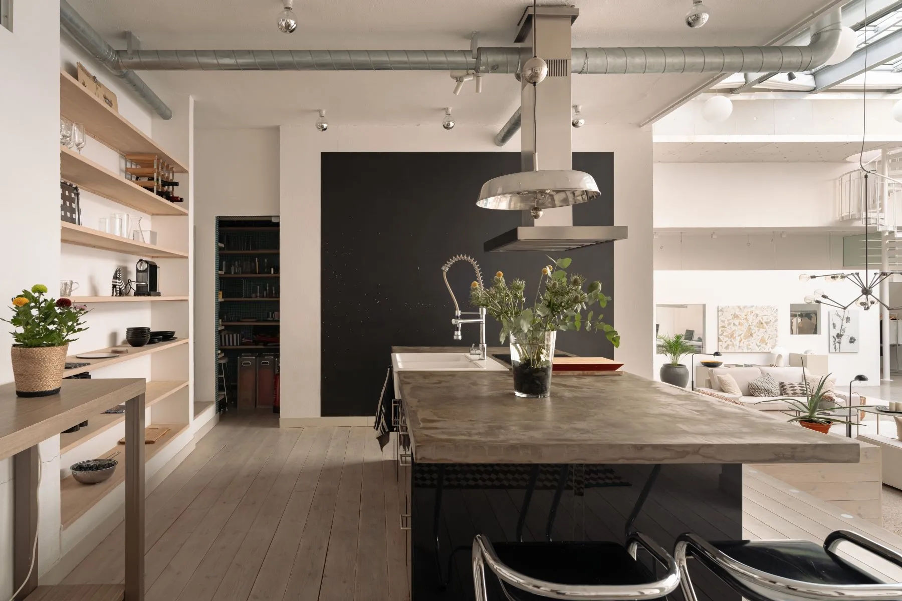 Industrial-style kitchen and dining island beneath sculptural pendant lighting