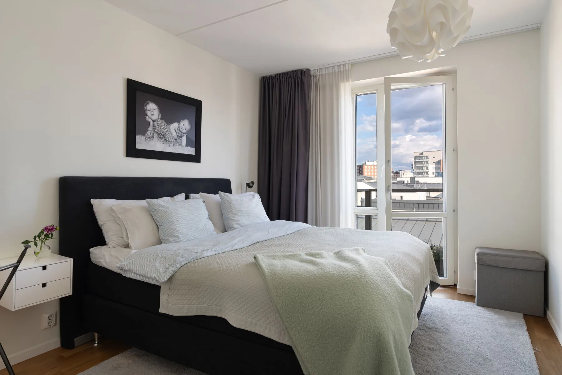 Principal double bedroom with balcony access and calm neutral finishes