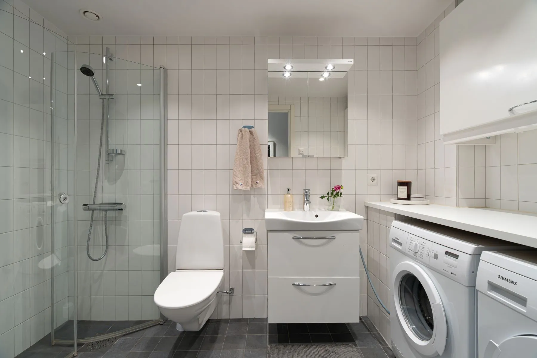 Contemporary bathroom and laundry room with shower, vanity and washing machine