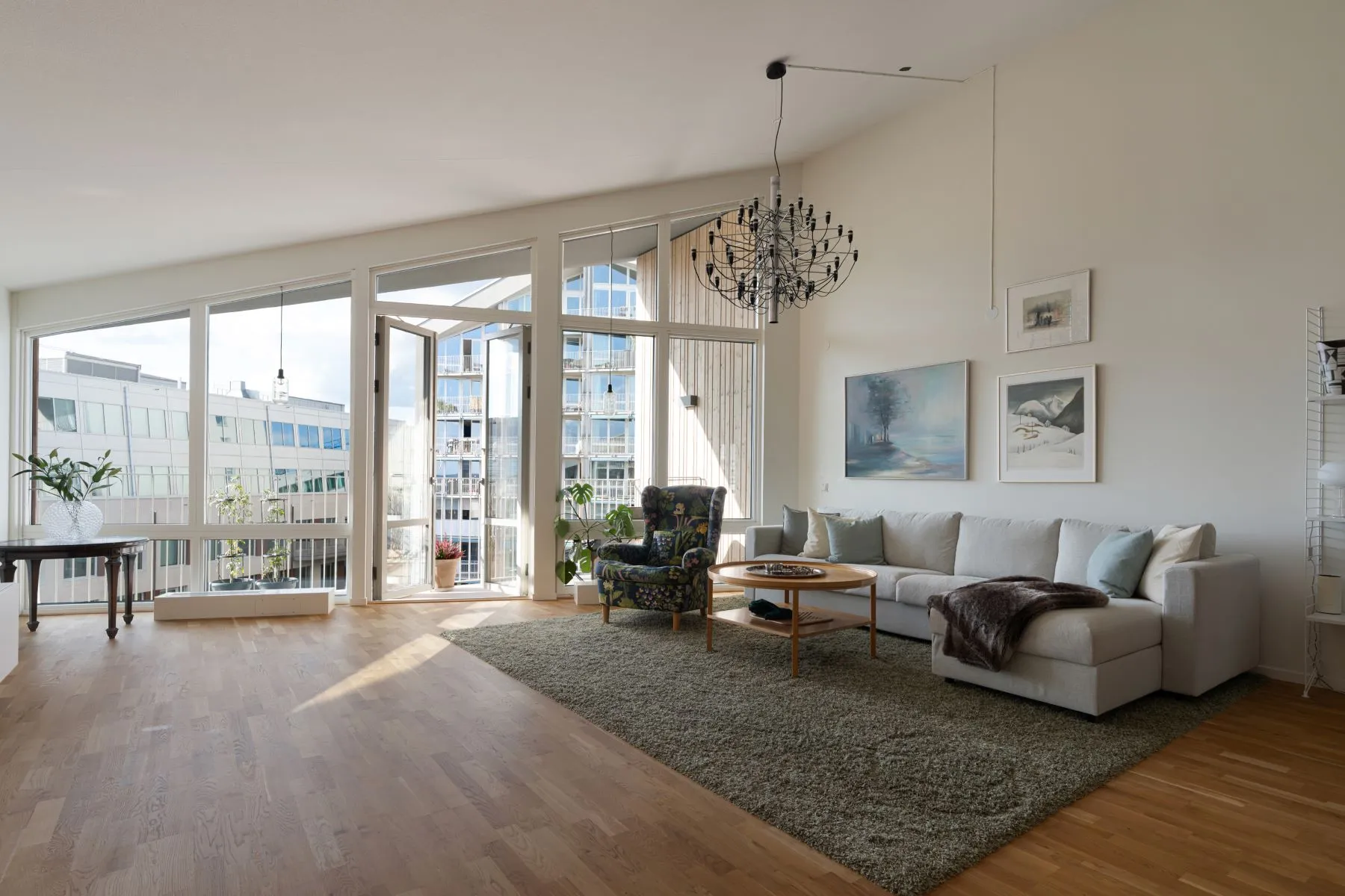Spacious Scandinavian lounge with white sofa and private balcony access