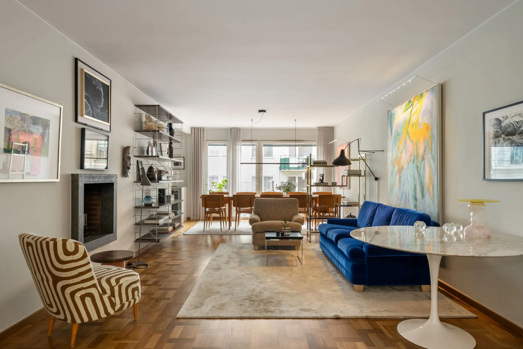 Elegant Östermalm reception room with fireplace, blue sofa and dining area