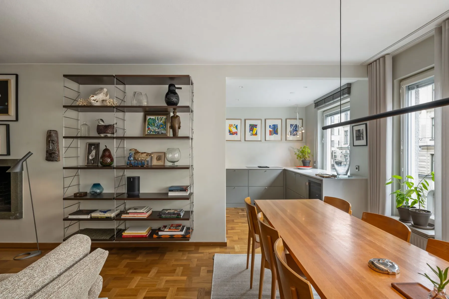 Dining table beside curated display shelving and the premium fitted kitchen