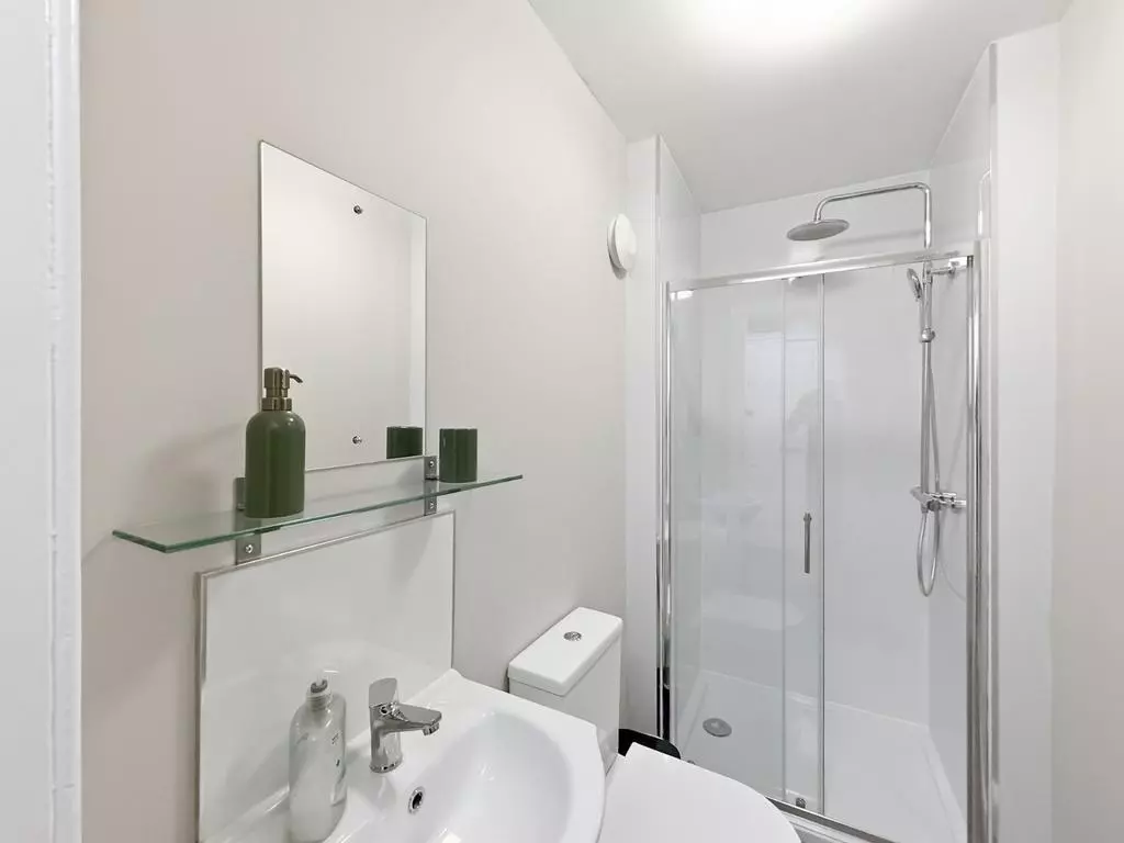 Modern shower room with glass enclosure and heated towel rail