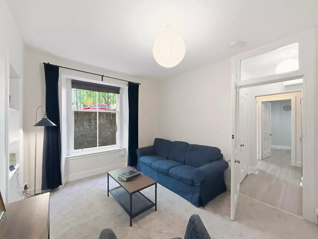 Bright living room with blue sofa and garden-facing window
