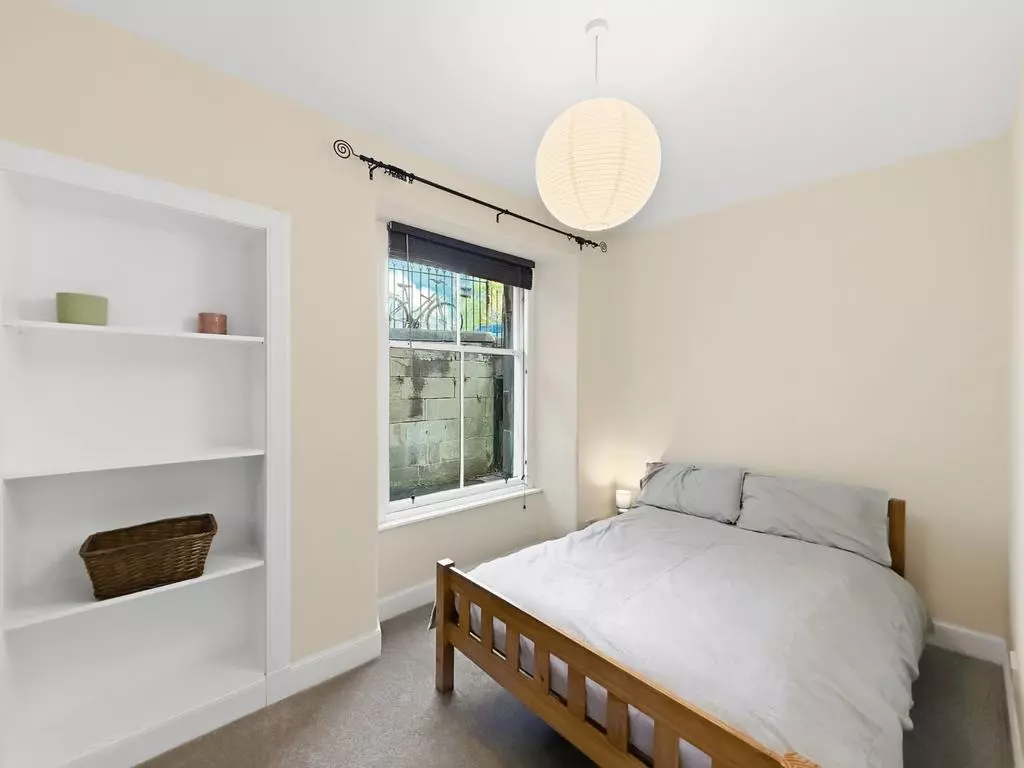 Peaceful double bedroom with built-in shelving and garden outlook
