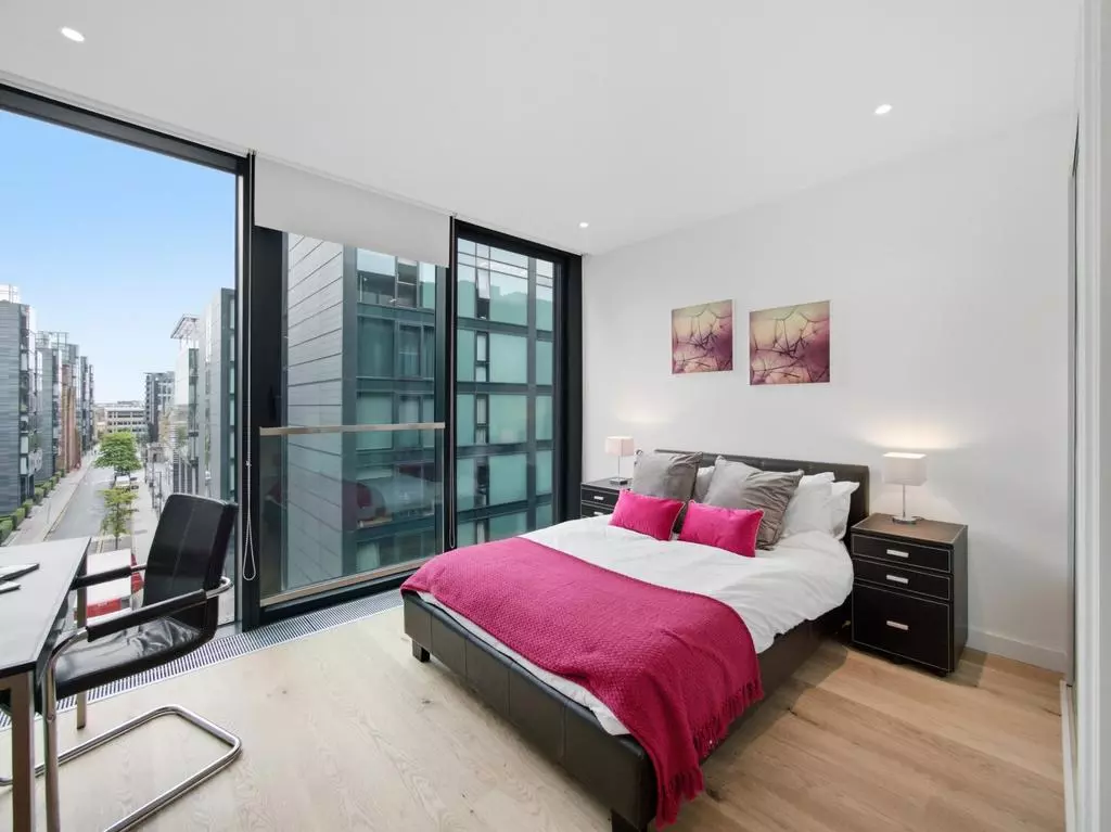 Principal double bedroom with floor-to-ceiling windows and city views