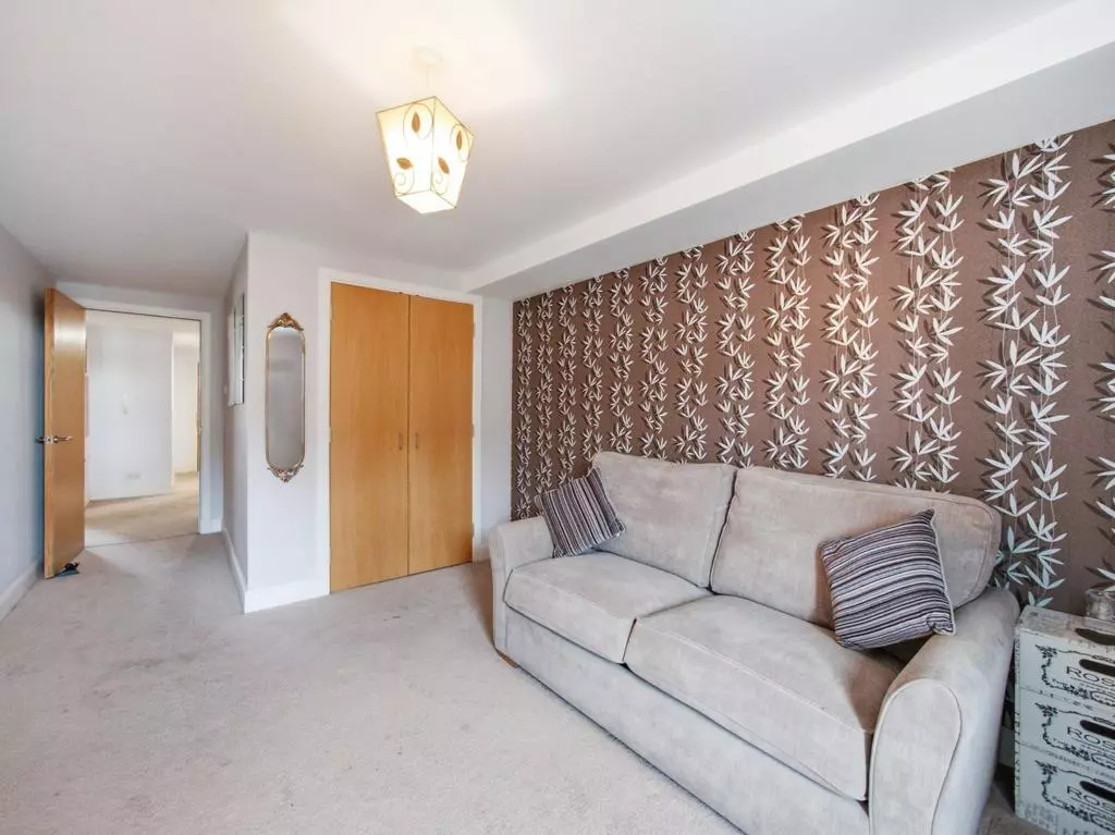 Second bedroom with built-in wardrobe and patterned feature wall