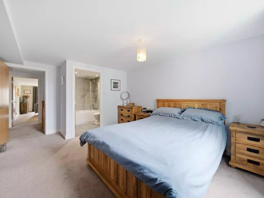 Spacious principal bedroom viewed toward the en-suite bathroom