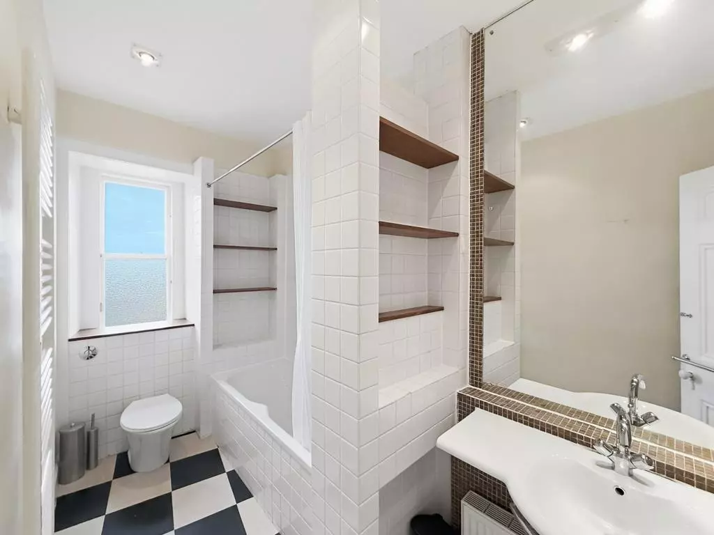 Bathroom with white suite, bathtub and storage shelving
