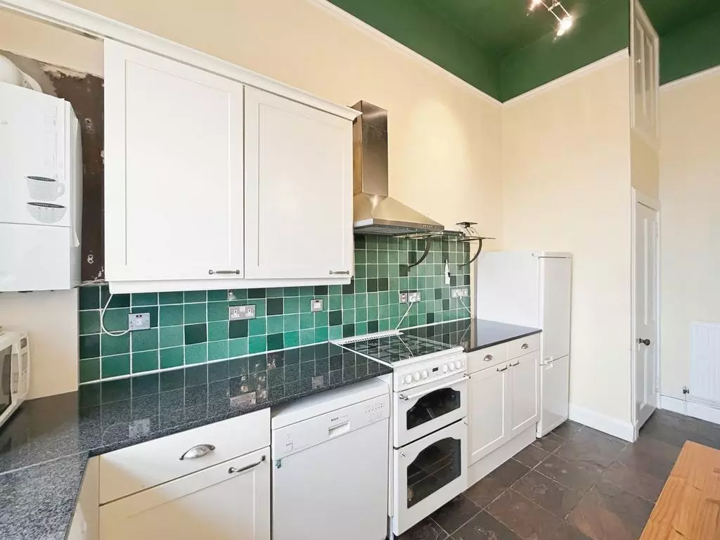 Fitted kitchen with white cabinetry and freestanding appliances