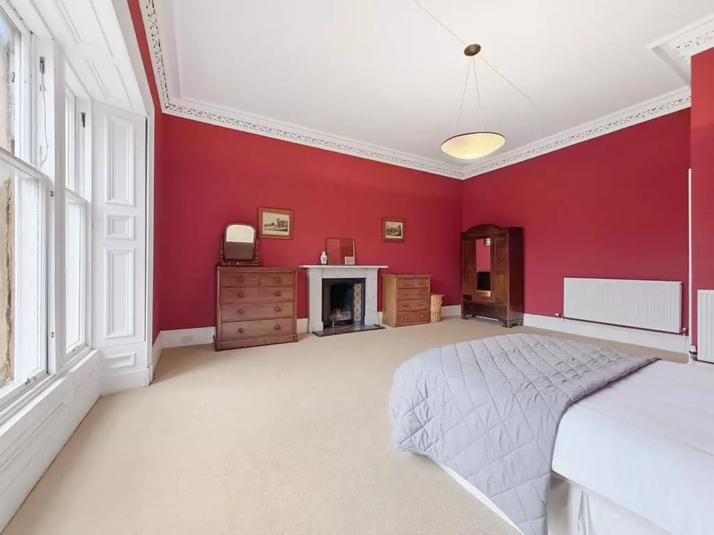 Double bedroom with red walls, period cornicing and fireplace
