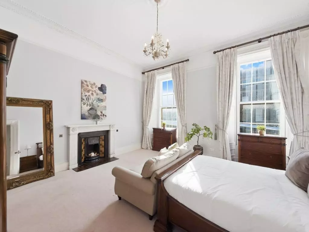 Generous double bedroom with fireplace and elegant sash window