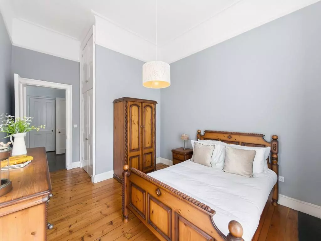 Double bedroom viewed toward the entrance and freestanding wardrobe