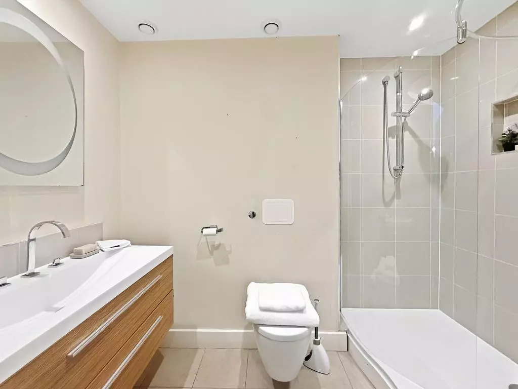 Modern bathroom with bathtub, overhead shower and vanity storage