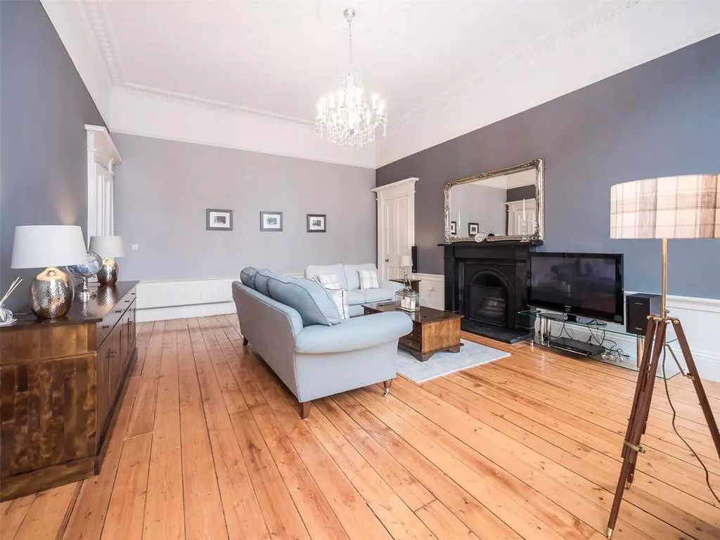 Spacious Georgian sitting room with timber flooring and fireplace