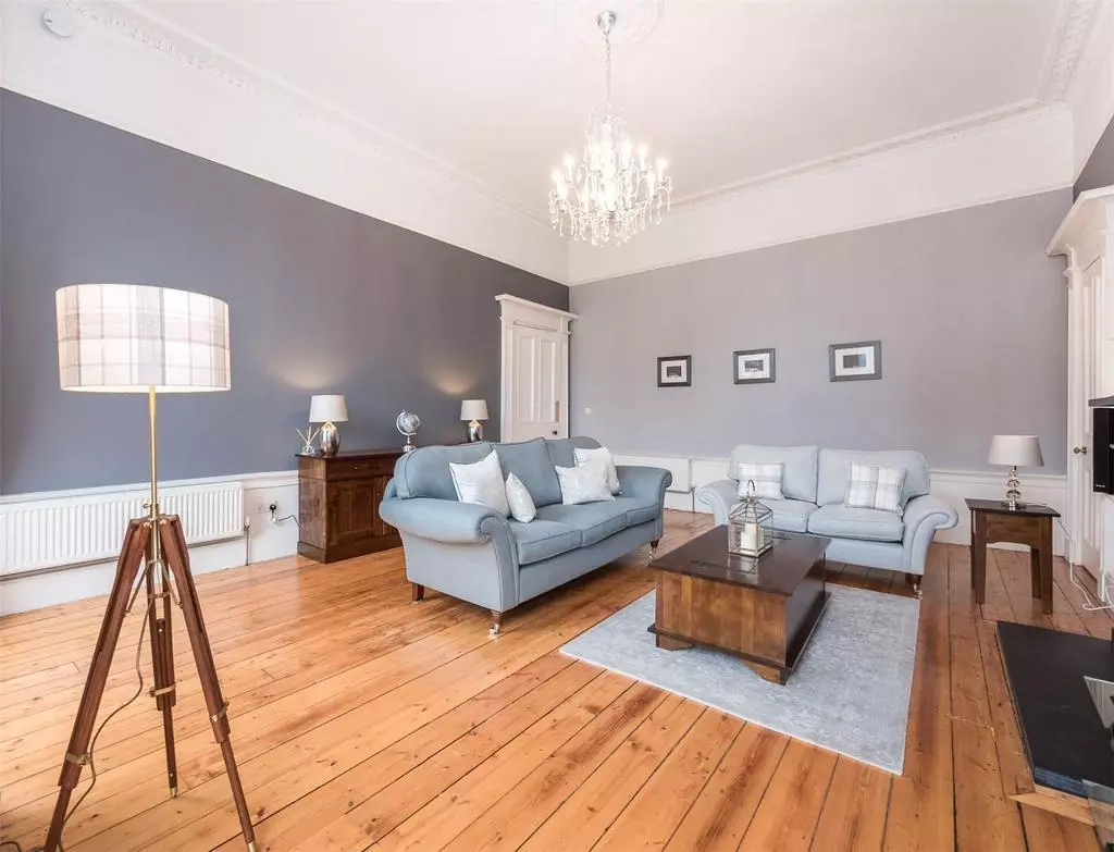 Large living room with high ceiling, chandelier and original features