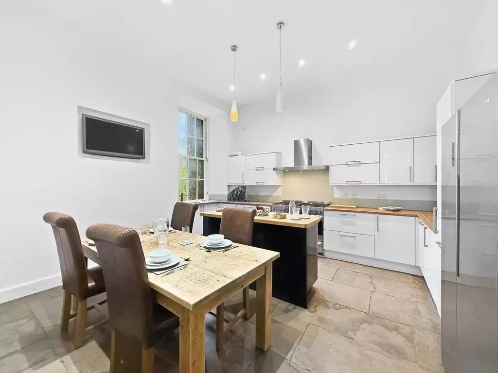 Dining kitchen with central island and table beside the window