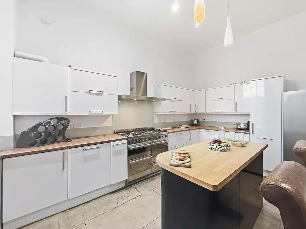 Contemporary white kitchen with timber worktops and breakfast island