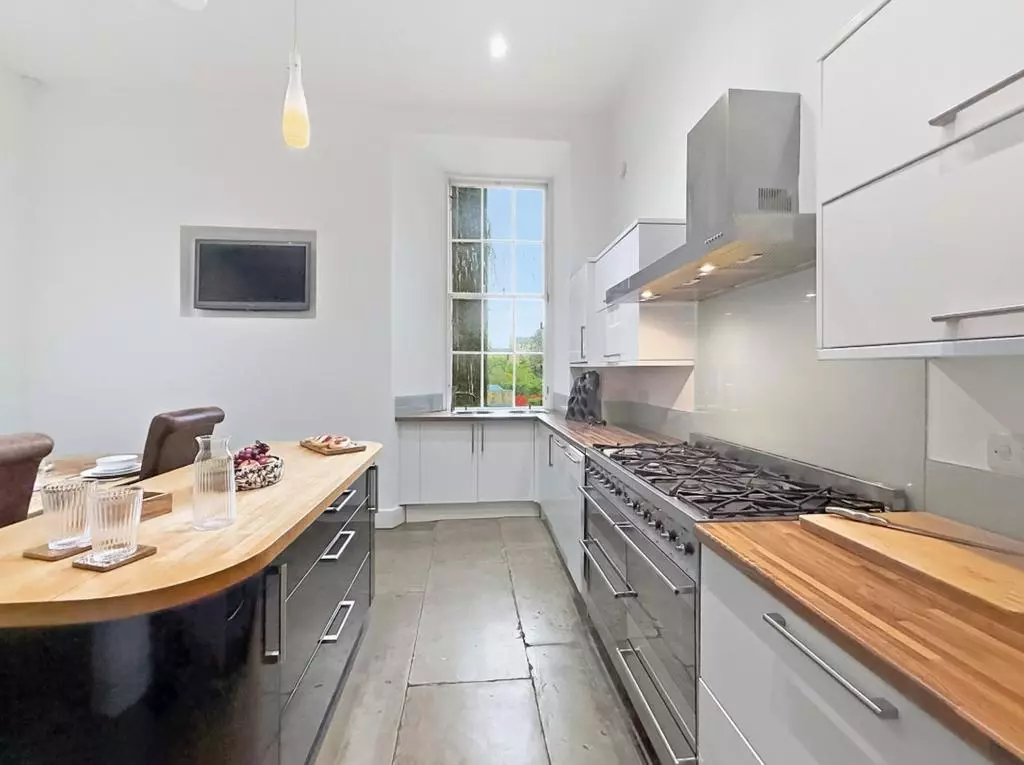 Bright kitchen work area with sash window and ample cabinetry