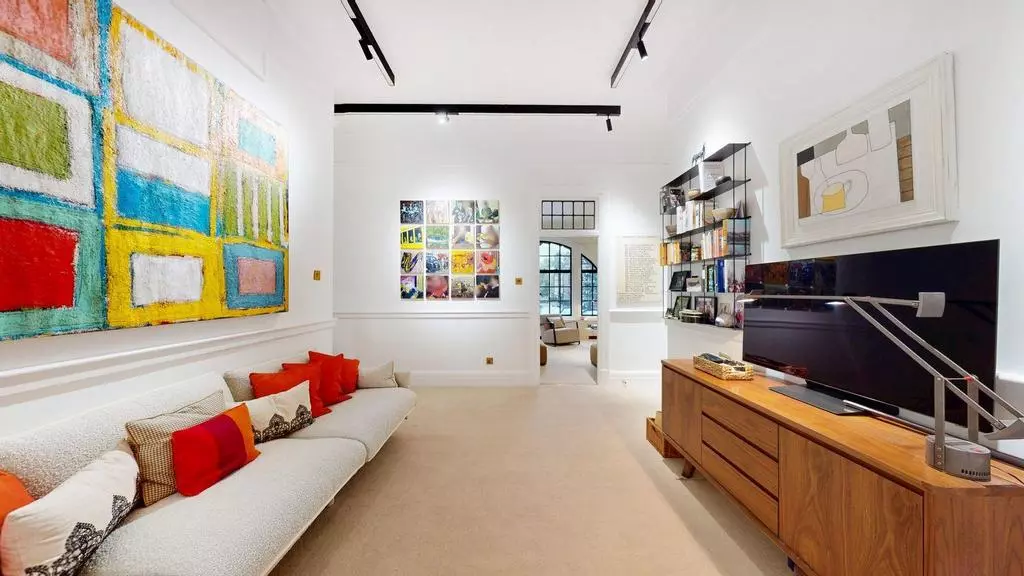 Media room with long sofa, colourful artwork and library storage