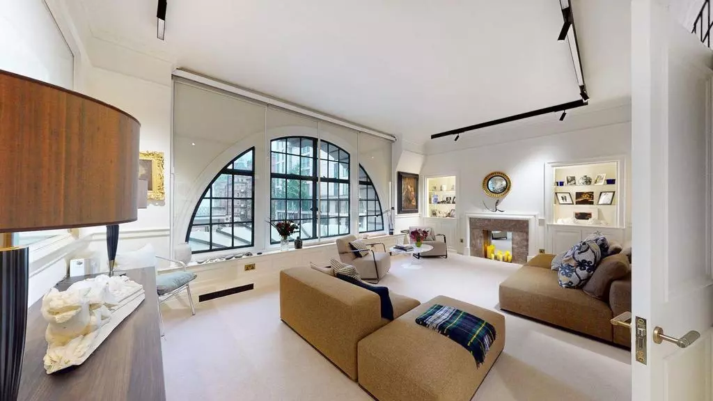 Spacious lounge with contemporary seating, fireplace and display shelving