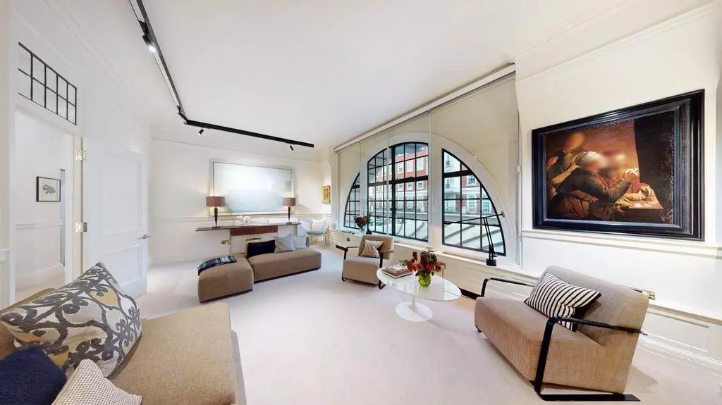 Elegant reception room with framed artwork and westerly-facing arched window