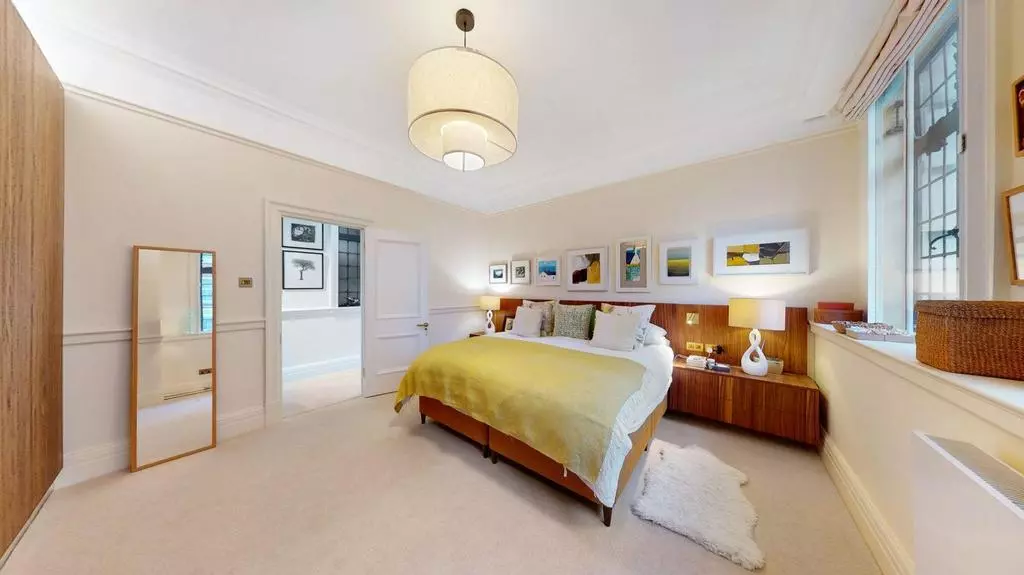 Double bedroom with built-in storage, artwork and windows on two sides