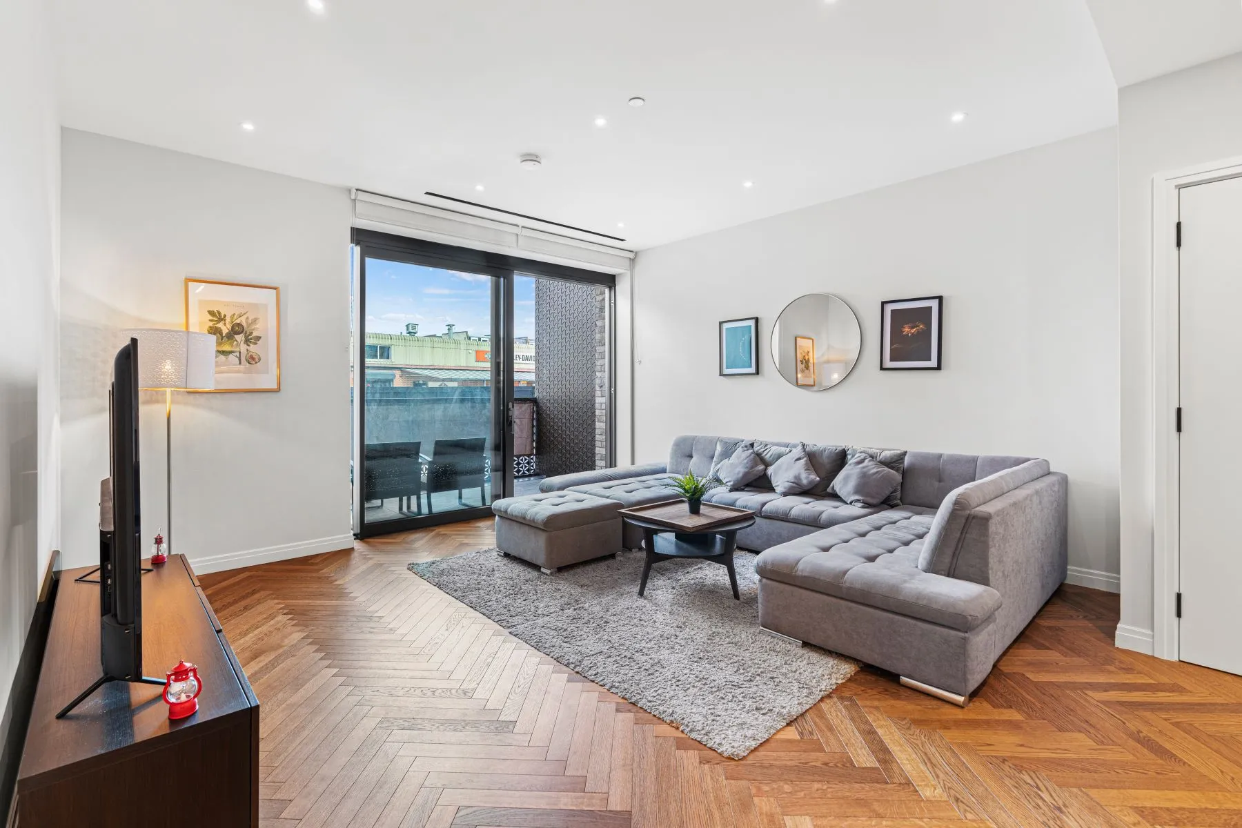 Bright lounge with herringbone flooring and private balcony access