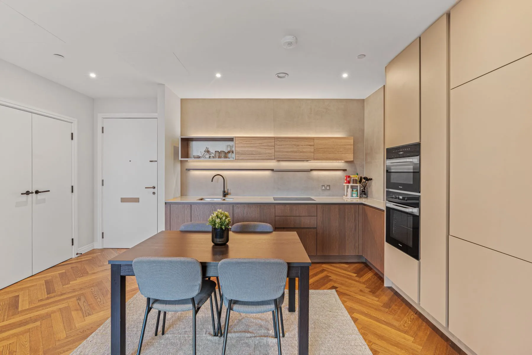 Kitchen dining area with streamlined cabinetry and timber table