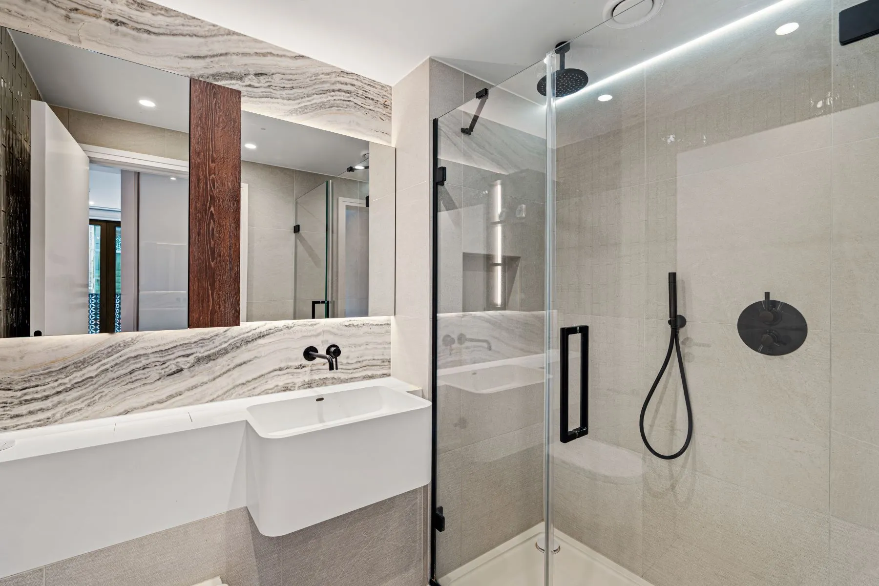 Marble-finished en-suite bathroom with glass walk-in shower